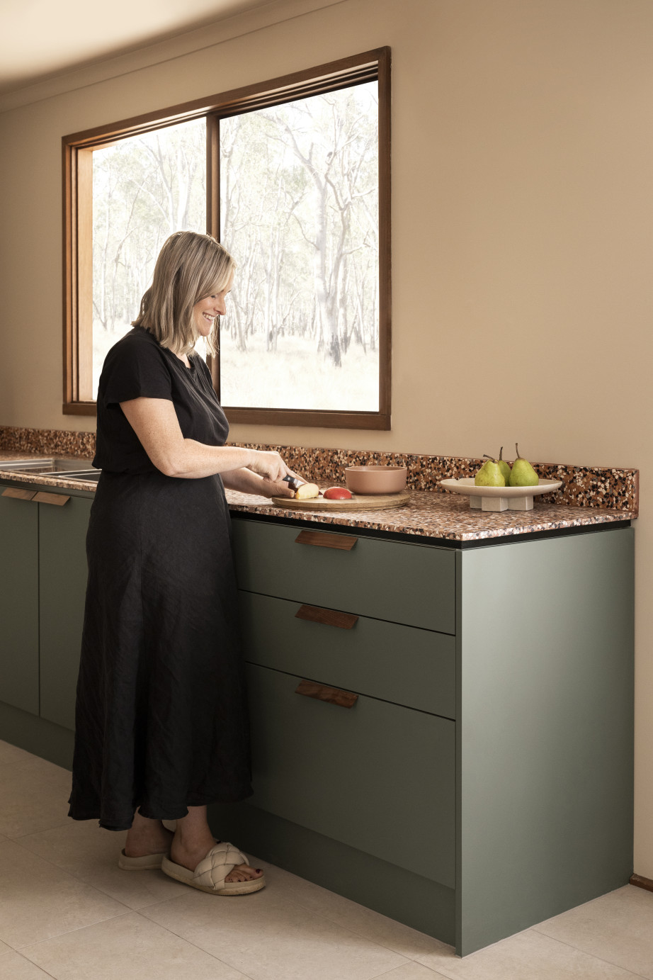 Taeler Jordan chopping fruit in Green Slate Haven Kitchens 
